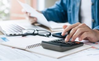 Investors are calculating profits and costs with calculators, growth and investment chart analysis, business planning and strategies to maximize sales profits. Long term business plan.